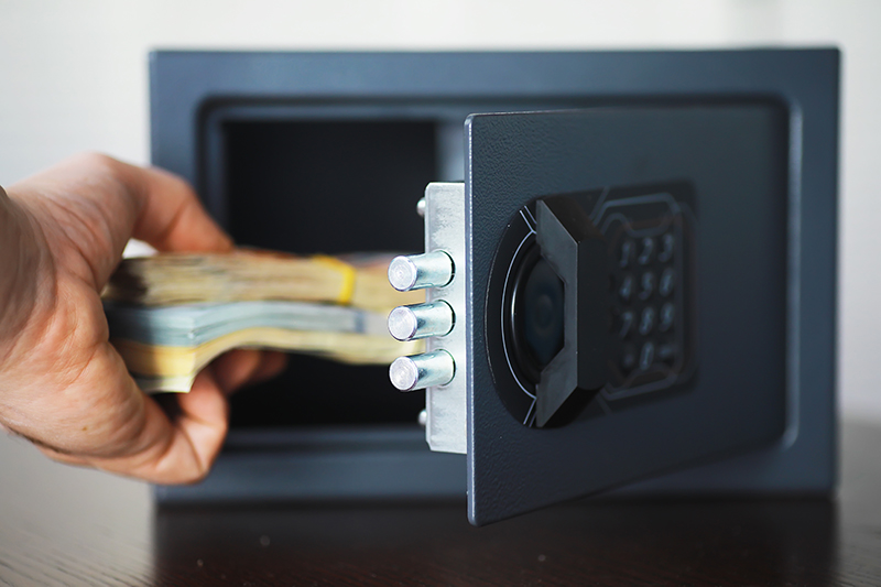hand placing money into digital safe uk