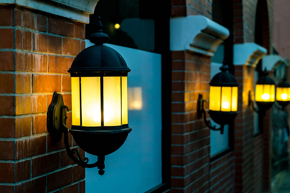 lamp against red brick wall night