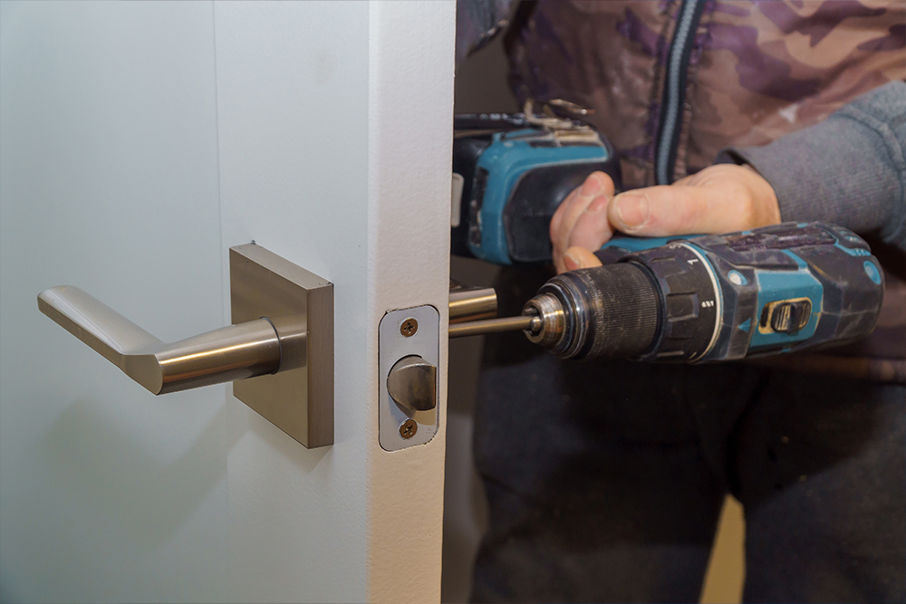 install door handle with lock carpenter tighten screw using electric drill